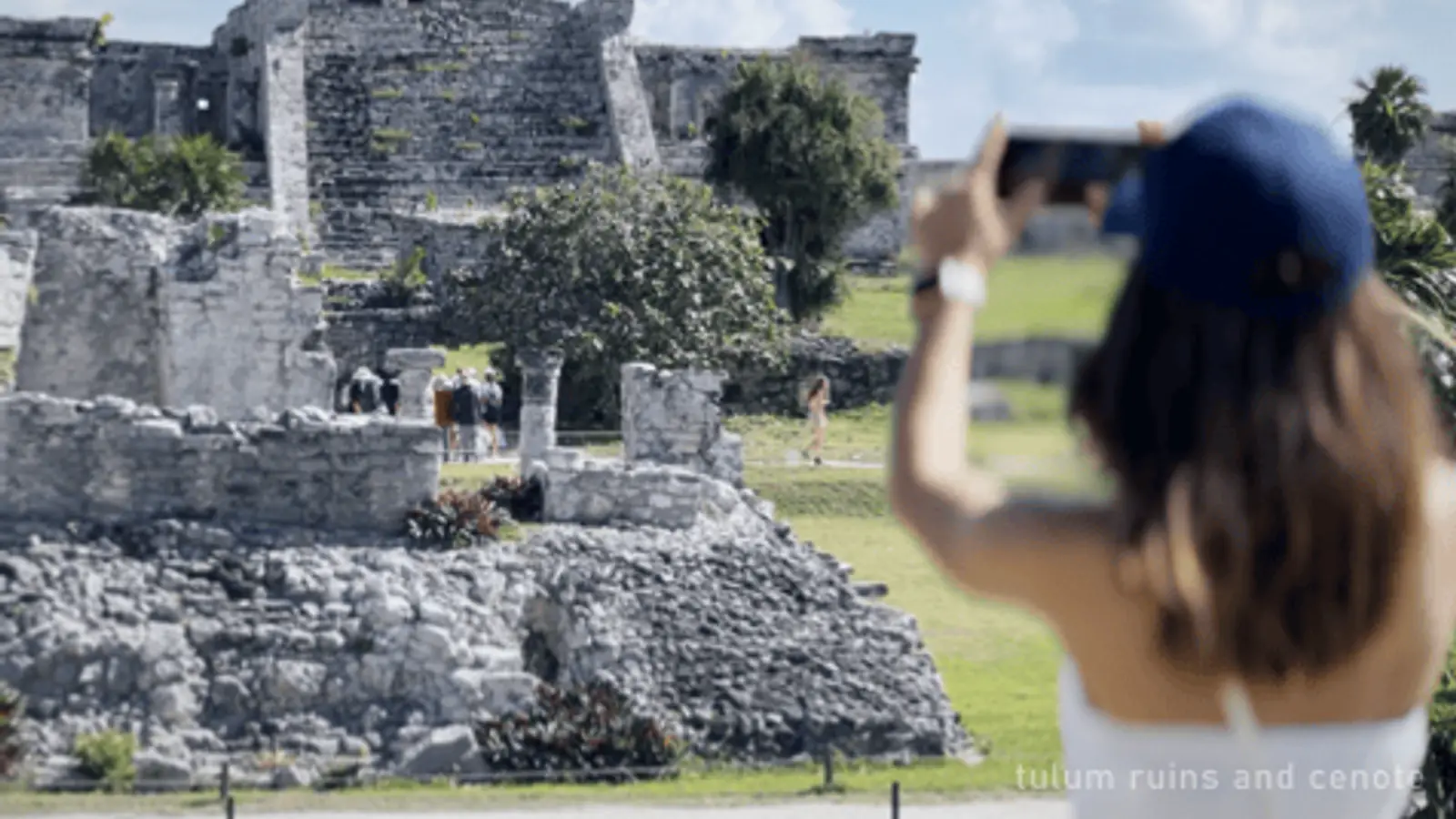 A visitor photographing the Tulum ruins with a phone — photo from the booking listing